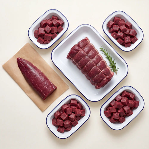 Raw venison on a white surface with various cuts displayed.